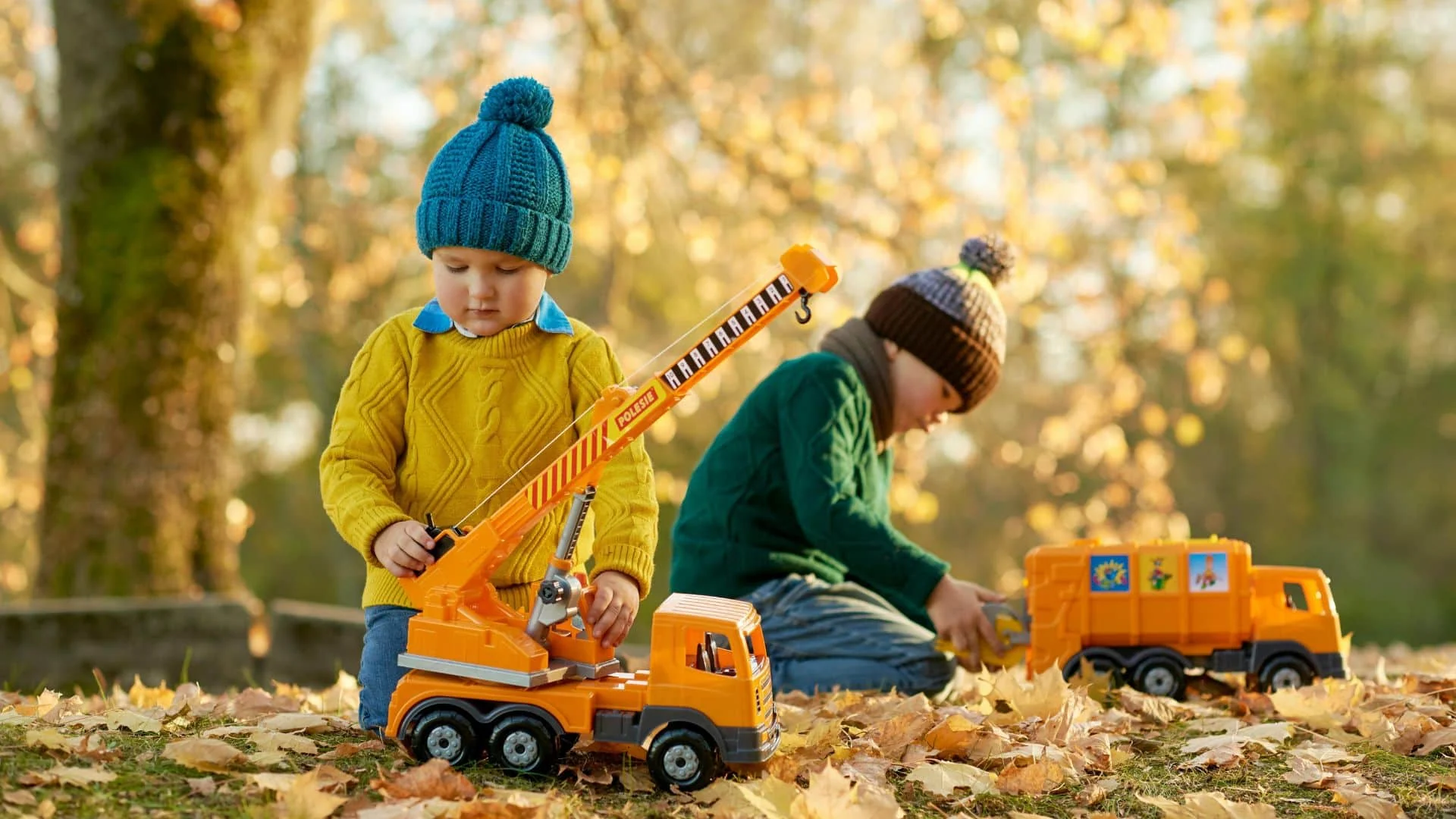 Children playing with toy trucks outdoors