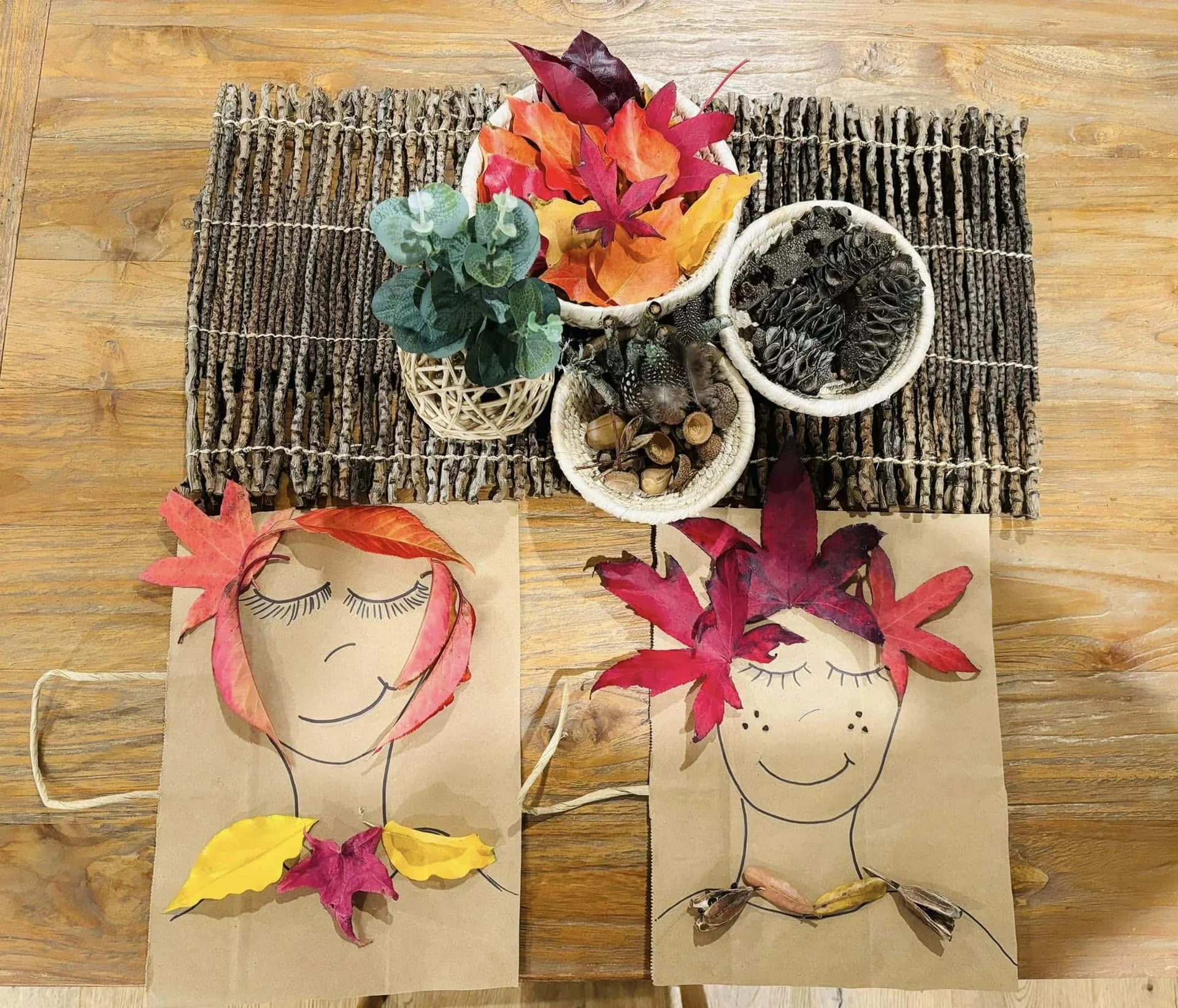 Children's nature-inspired artwork made with colourful autumn leaves and natural materials