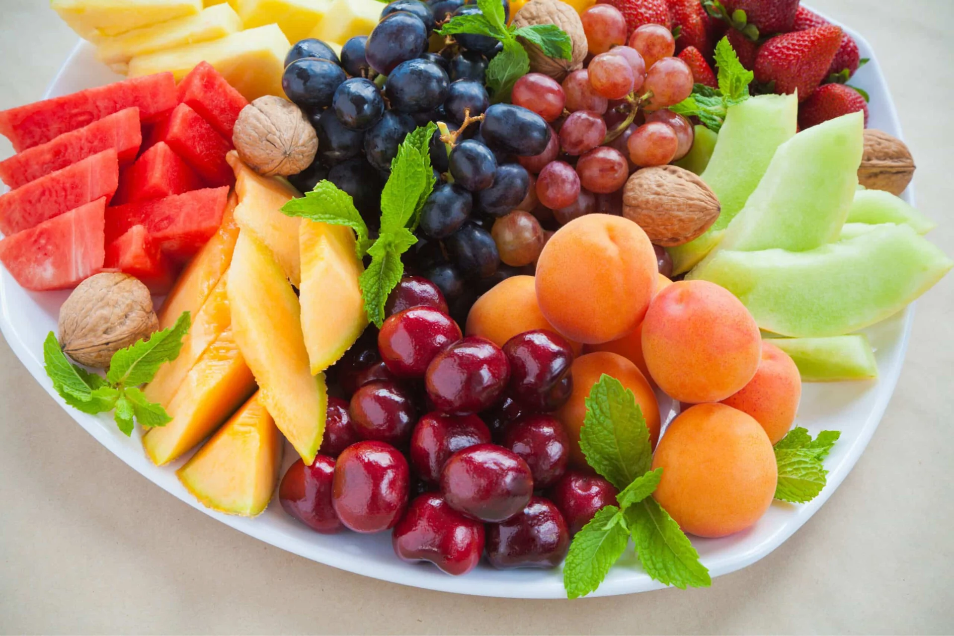 Colorful fruit platter with nuts.
